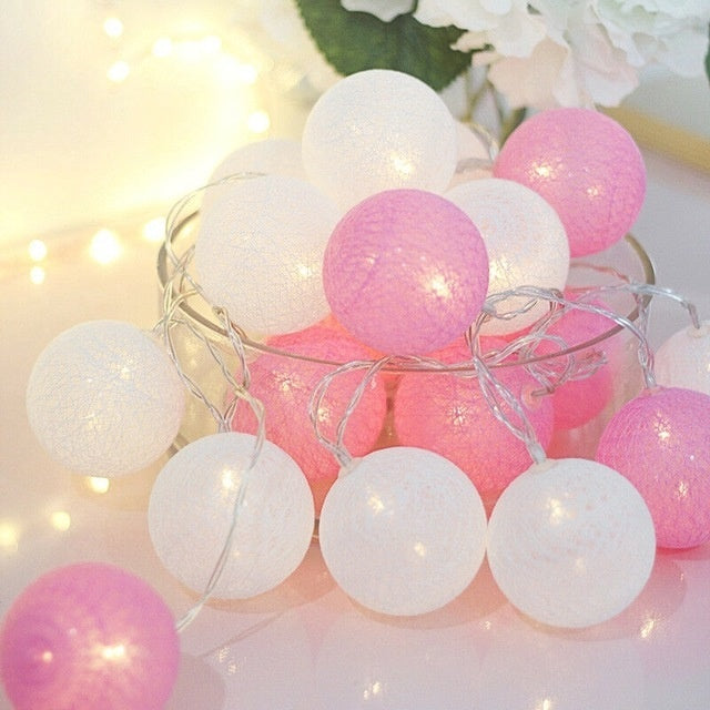 Pink and white globe string lights with clear wire.