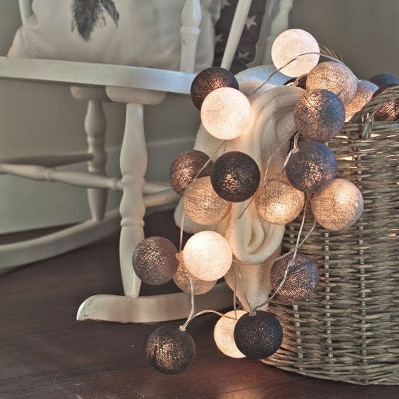 Decorative string lights with cotton ball globes in black, white and gold colors.
