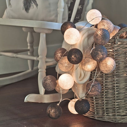 Decorative string lights with cotton ball globes in black, white and gold colors.