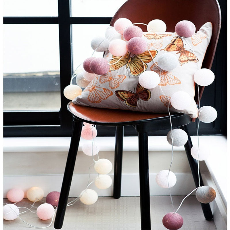 Led cotton ball lights featuring pink and white pom-pom garland with wooden beads made of cotton material