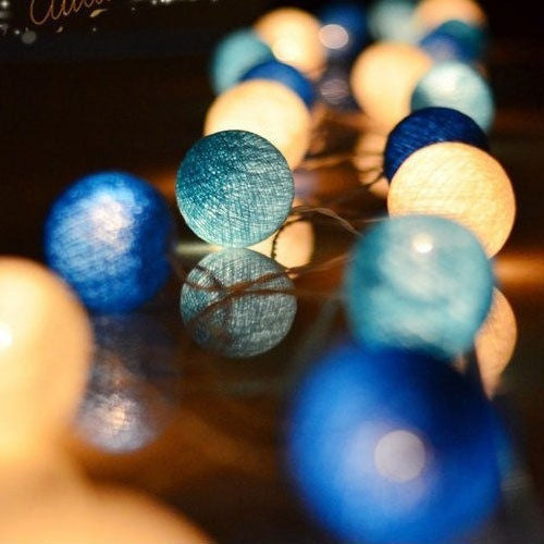 Blue and white cotton ball string lights with a bohemian design.