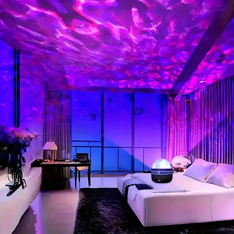 A sleek decorbites led galaxy star projector light in glossy white and black sits on the bed as a night light
