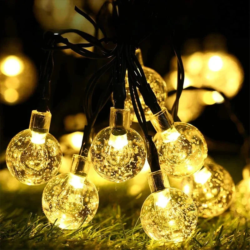 String lights featuring warm white led solar crystal globe bulbs with clear bubble-filled glass for outdoor use