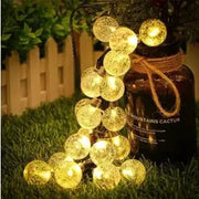 Warm white led solar crystal globe string lights with golden glass globes and rustic twine for outdoor use