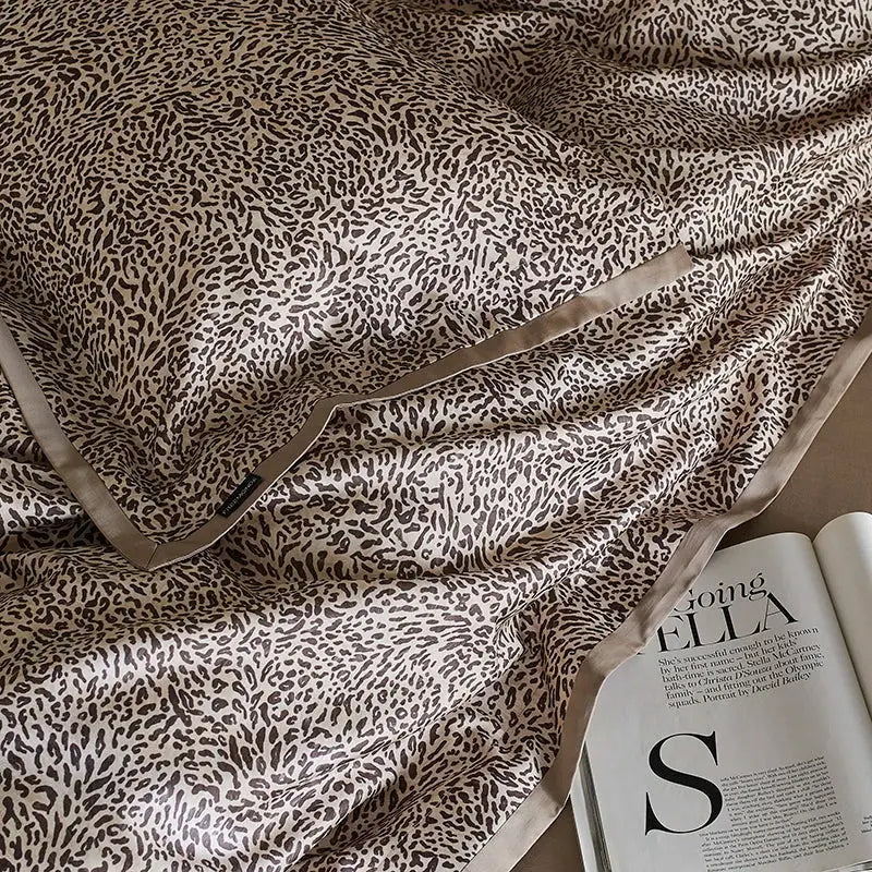 Beige and black satin leopard luxury bedding set featuring a bold brown print and matching piping by decorbites