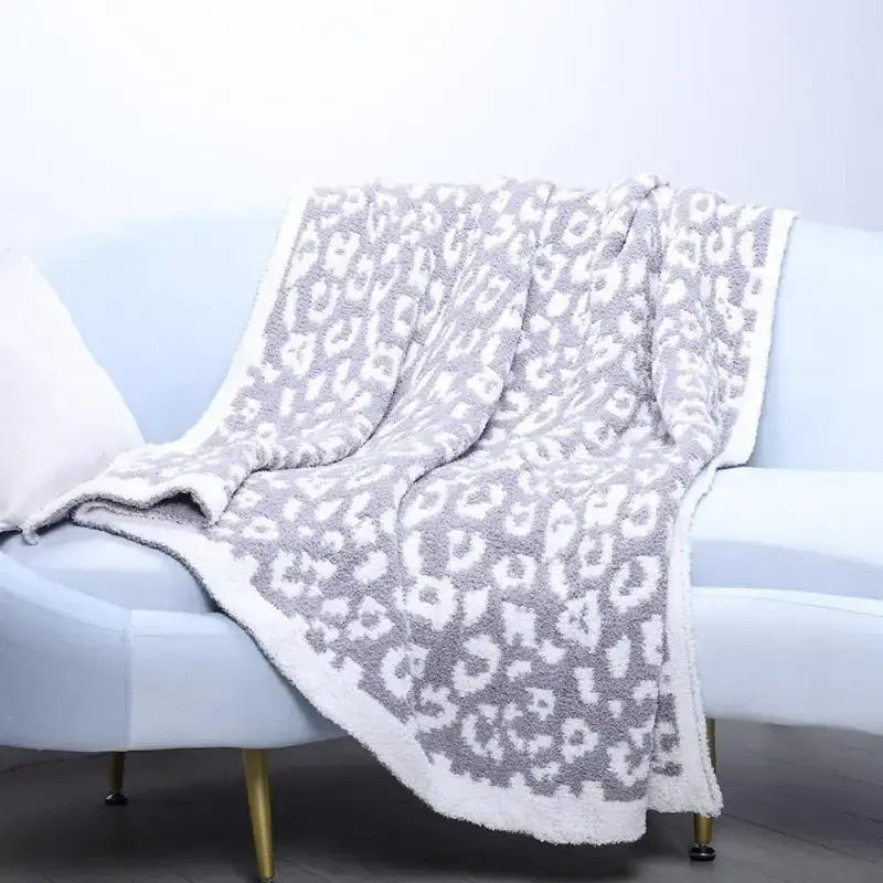 A plush gray and white leopard print fleece blanket with a soft textured surface for bedroom or sofa decorbites use