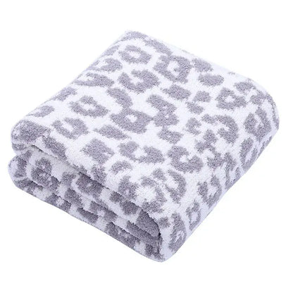 A plush white fleece blanket with a soft gray leopard print pattern perfect for decorbites leopard print decor