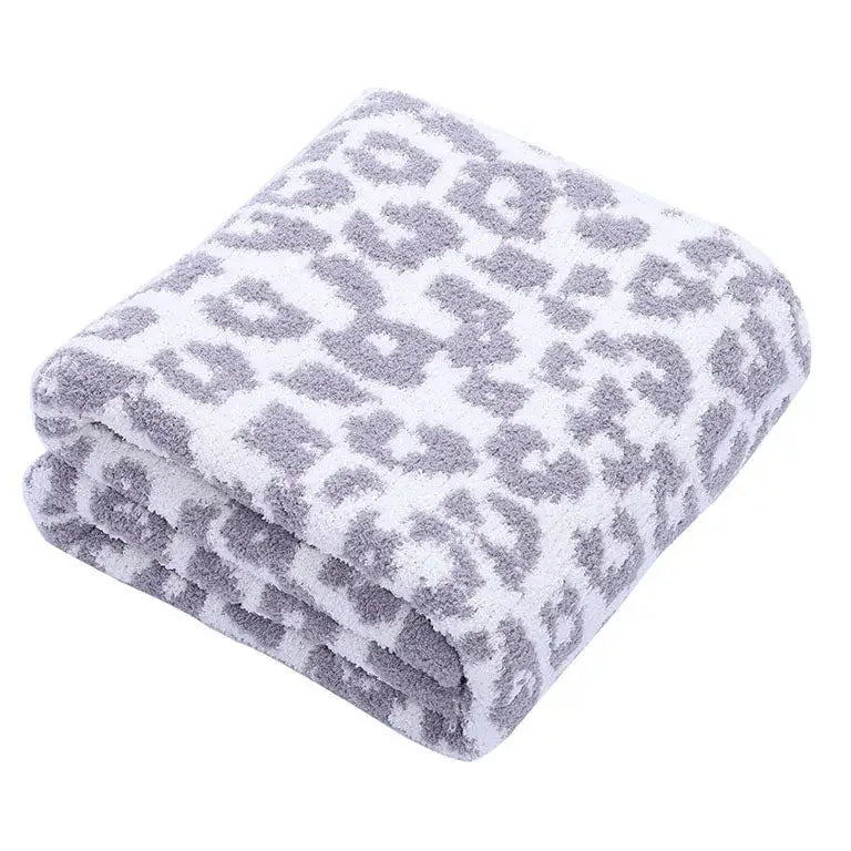 A plush white fleece blanket with a soft gray leopard print pattern perfect for decorbites leopard print decor