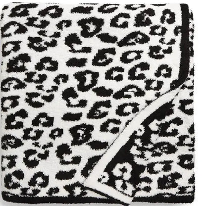 A plush white fleece blanket with bold black leopard print pattern from decorbites ideal for bedroom or sofa decor