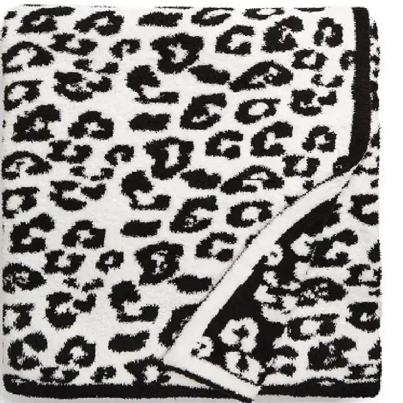 A plush white fleece blanket with bold black leopard print pattern from decorbites ideal for bedroom or sofa decor