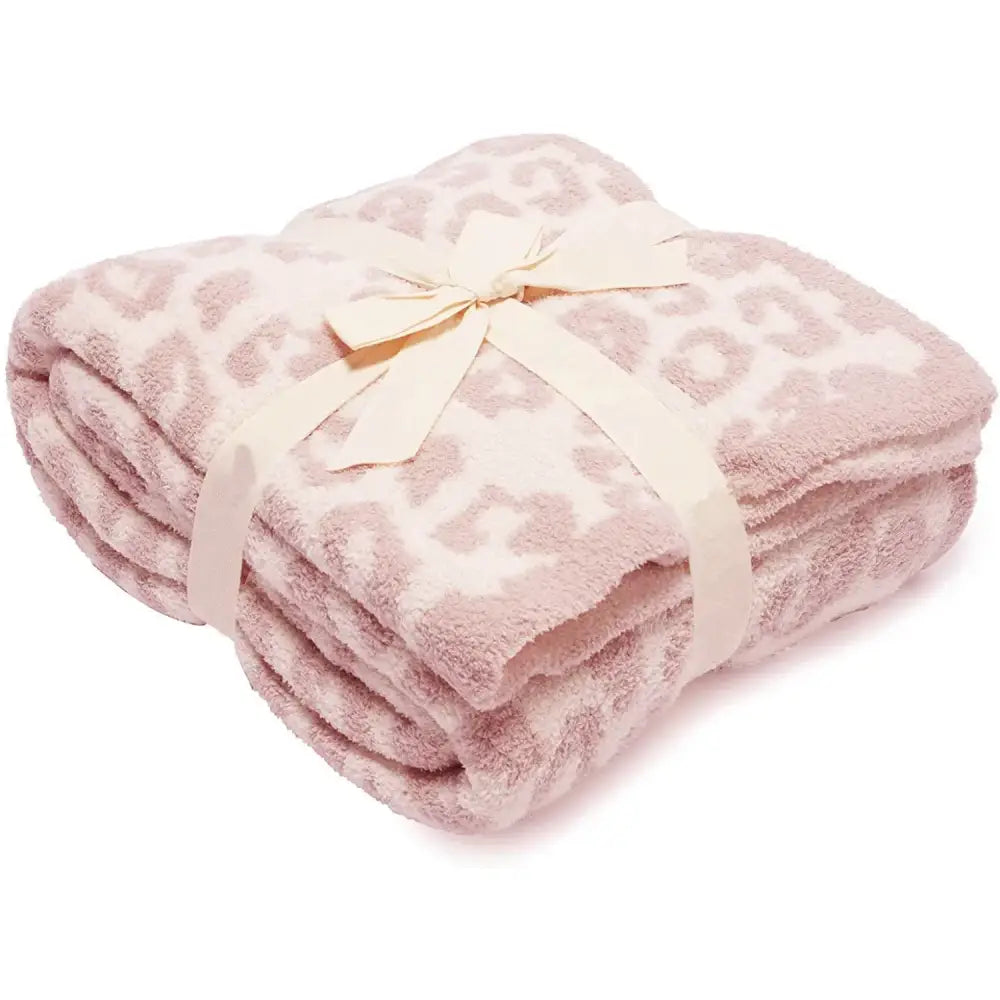 A soft pink leopard print fleece blanket tied with a cream satin ribbon for bedroom or sofa decorbites use