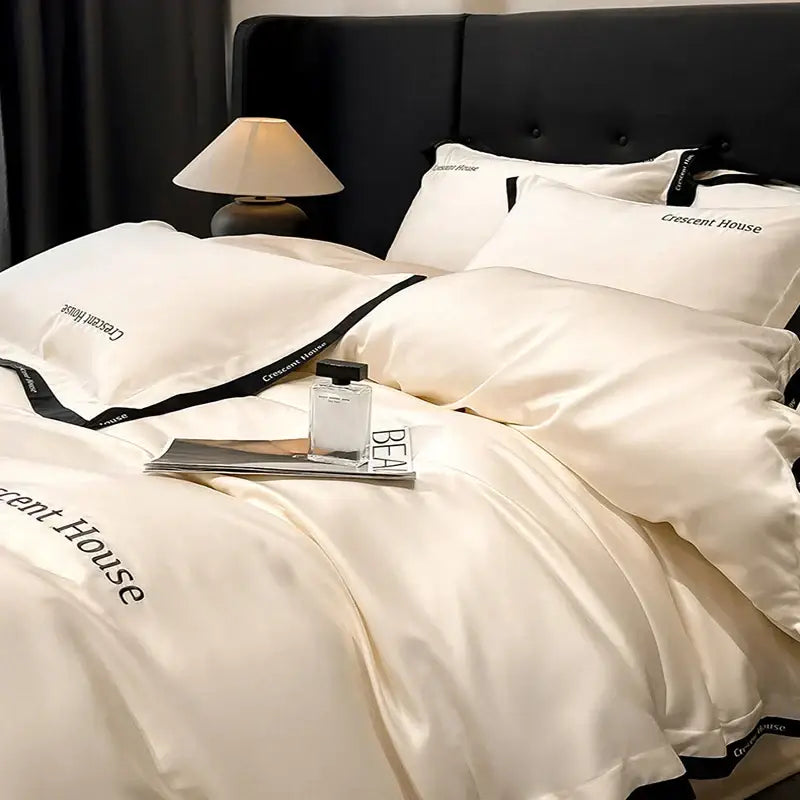 Cream-colored satin bed set with black trim and crescent house embroidery in decorbites ice silk duvet cover style