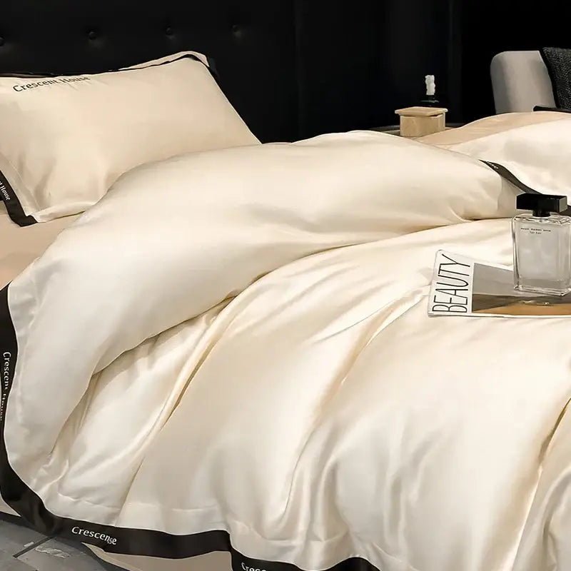 Cream-colored satin duvet cover bed set with black trim and crescent house branding for decorbites ice silk collection