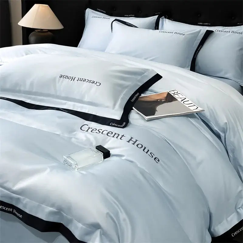 Light blue and black ice silk duvet cover bed set featuring crescent house branding and black trim by decorbites