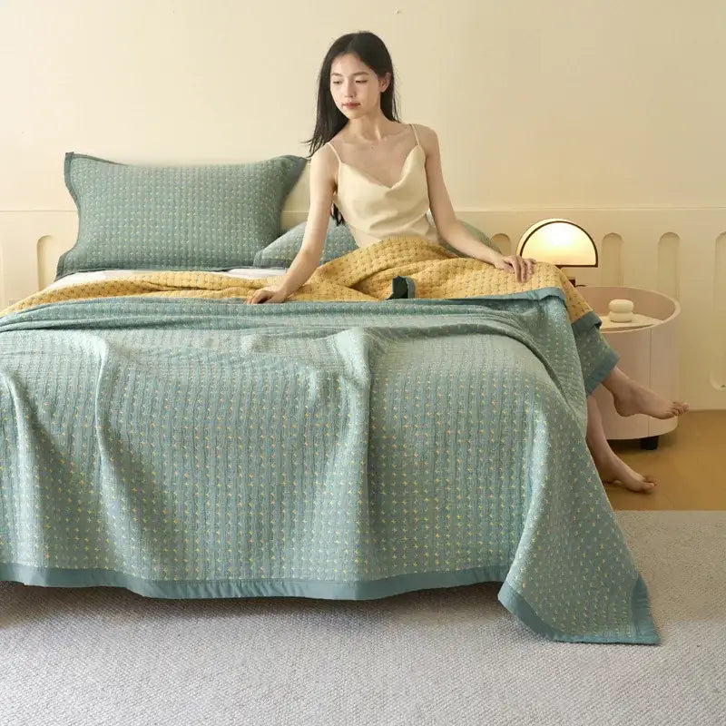 A soft mint green decorbites cotton summer cool quilt towel blanket with quilted texture and yellow dot accents