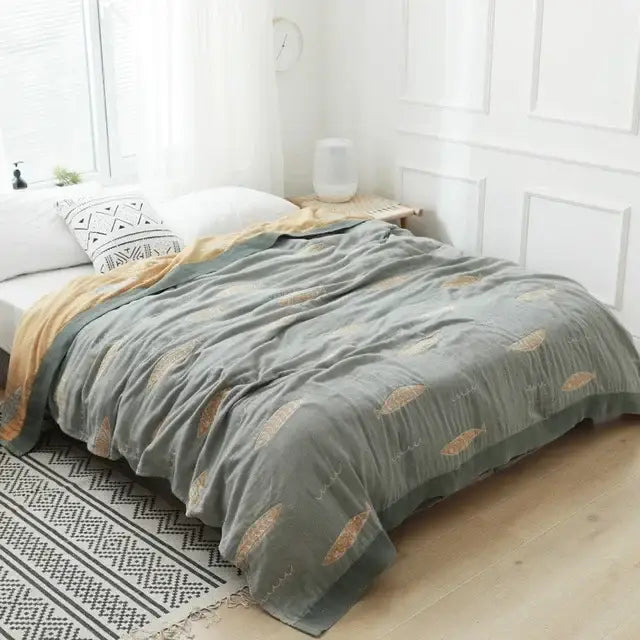 A soft sage green decorbites cotton gauze towel throw with golden fish embroidery for bedroom decor