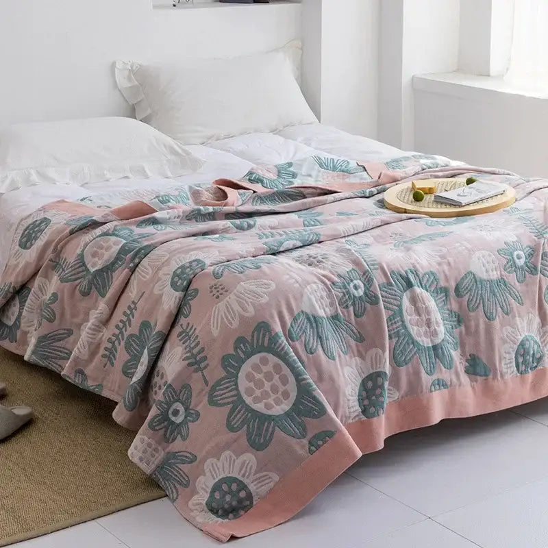 Pink floral throw blanket with teal and white botanical patterns made of soft plush decorbites cotton gauze towel throw
