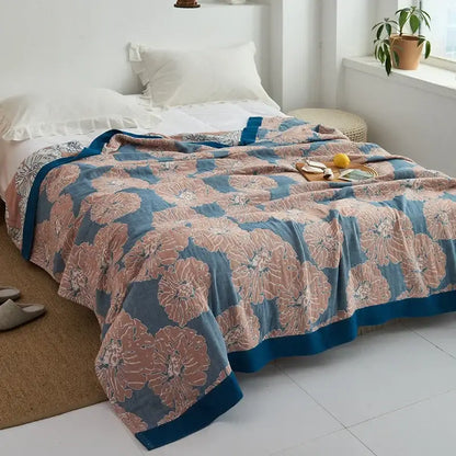 A soft blue and blush pink floral decorbites cotton gauze towel throw with a solid navy border for bedroom decor
