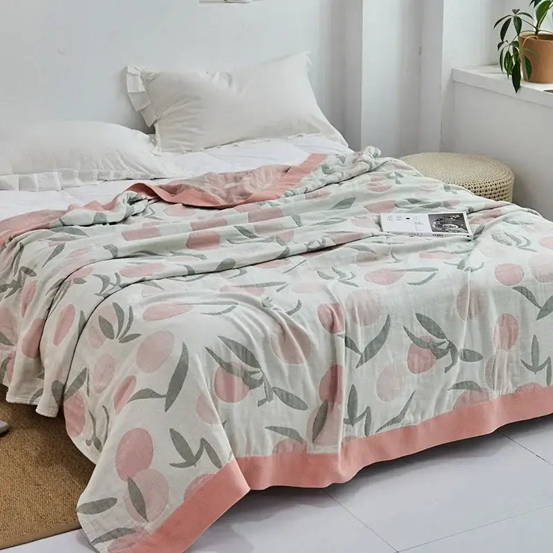Light blue and white leaf cotton gauze towel throw with peach-toned cotton gauze towel featuring pink peaches decorbites cotton gauze