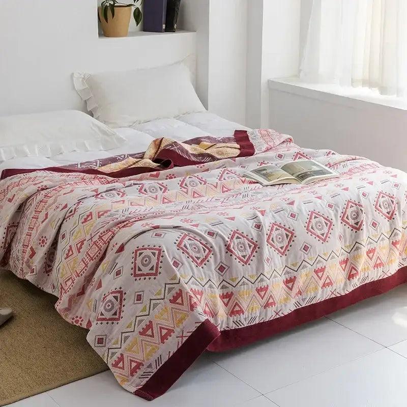 Light blue and white leaf cotton gauze towel throw with a soft red yellow and beige geometric quilted design decorbites cotton gauze