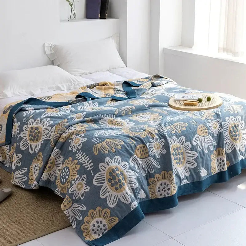 Light blue and white leaf cotton gauze towel throw with blue floral design and gold accents in soft decorbites cotton gauze fabric