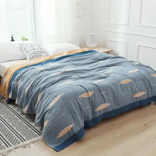 Light blue and white leaf decorbites cotton gauze towel throw with blue and gold fish pattern and fringed edges for bedroom decor