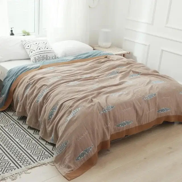 Beige decorbites cotton gauze towel throw with muted teal and brown leaf pattern featuring soft textured fabric
