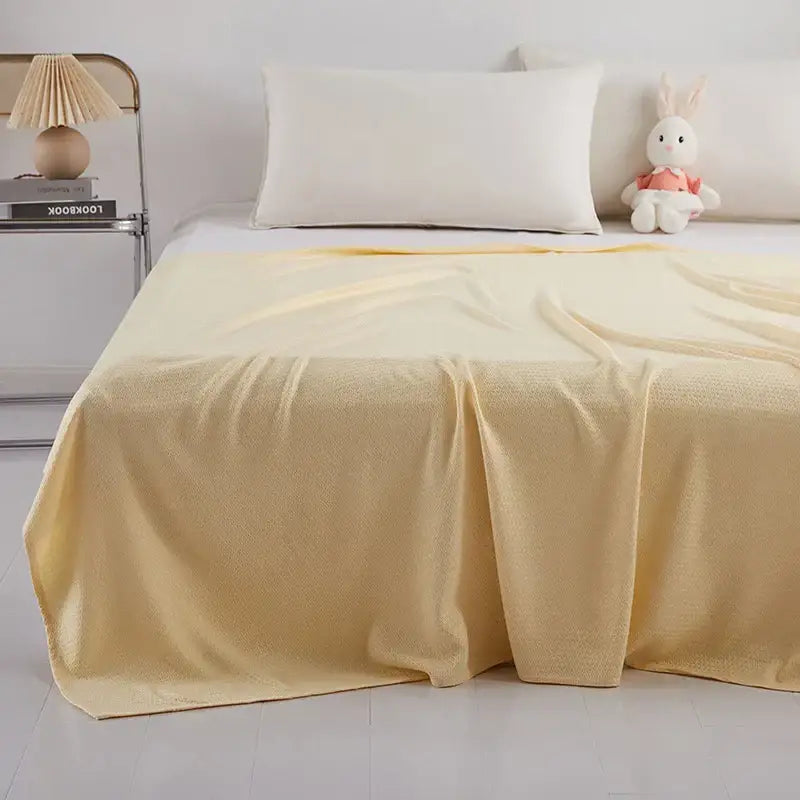 Soft pale yellow textured throw blanket draped over bed made of bamboo fiber for summer decorbites bamboo fiber use