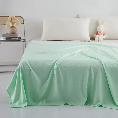 Light blue bamboo fiber summer quilt with a soft mint green textured bedspread featuring a diamond grid pattern
