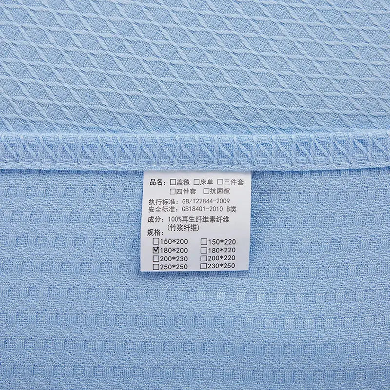 Light blue bamboo fiber summer quilt with textured woven pattern and white care label for bedroom use decorbites bamboo fiber