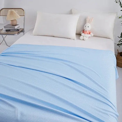 Light blue bamboo fiber summer quilt with diamond grid texture draped over a bed for decorbites bamboo fiber use