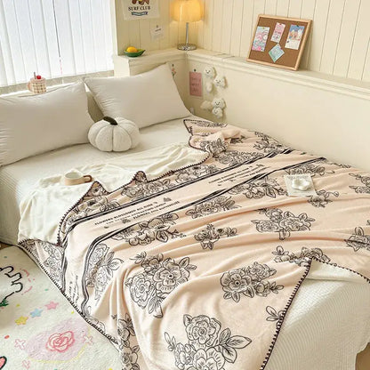 Soft blush pink fleece milk velvet blanket with black floral embroidery and decorative border for cozy decorbites cozy milk use