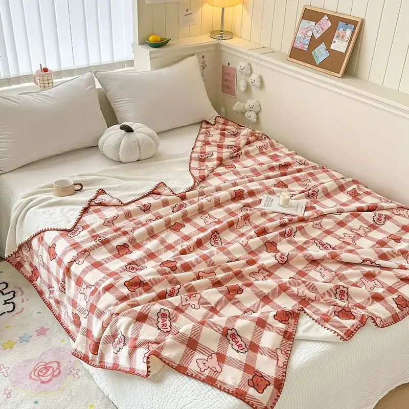 A cozy red and cream checkered milk velvet blanket featuring playful bear patterns and pom-pom trim by decorbites cozy milk