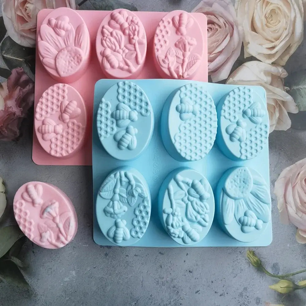 Light blue and pink bee silicone soap mold with intricate honeycomb and flower designs for kitchen baking use