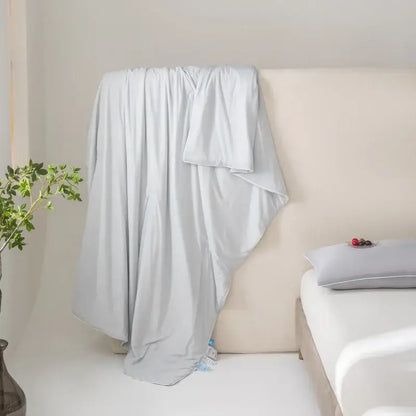 Light gray soft-textured cotton duvet cover draped on bed showcasing decorbites cool fiber summer blanket features