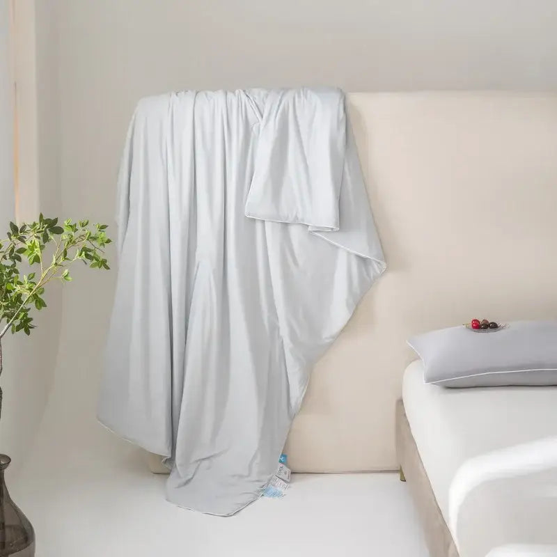 Light gray soft-textured cotton duvet cover draped on bed showcasing decorbites cool fiber summer blanket features