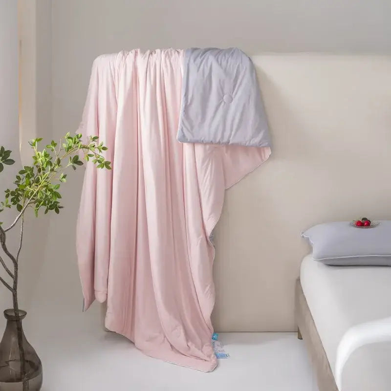 A soft pink and light gray decorbites cool fiber summer blanket featuring lightweight textured fabric for cooling comfort