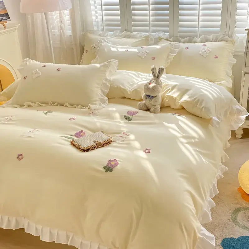 Cream-colored satin bedding set with ruffled edges and embroidered floral patterns enhancing cotton bedding set decorbites cartoon embroidery