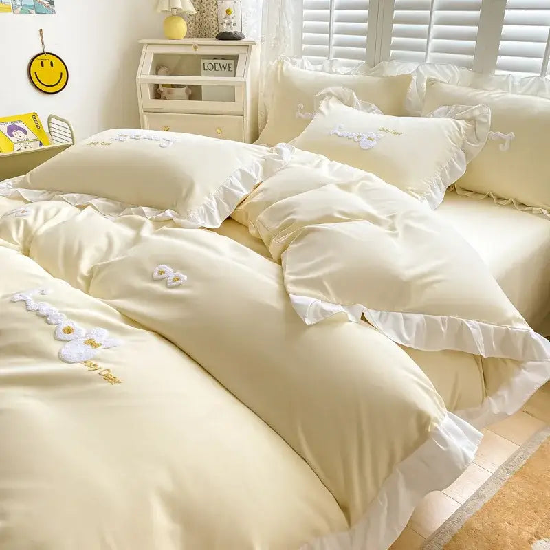 Light blue cotton bedding set with bunny embroidery and cream-colored bedding featuring white ruffles and floral appliqués