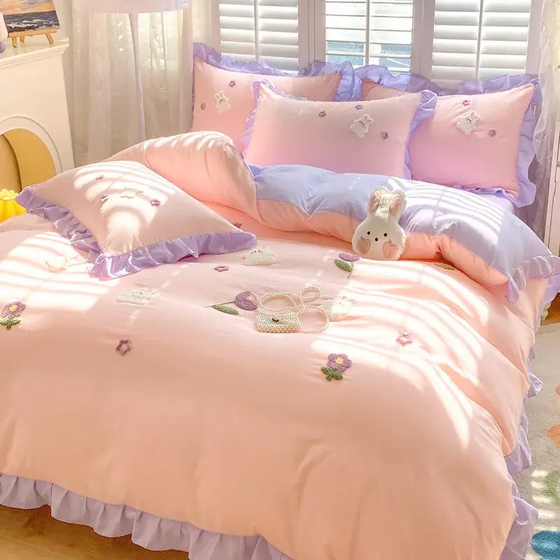 Pastel pink and lavender cotton bedding set with decorbites cartoon embroidery featuring floral and bunny motifs