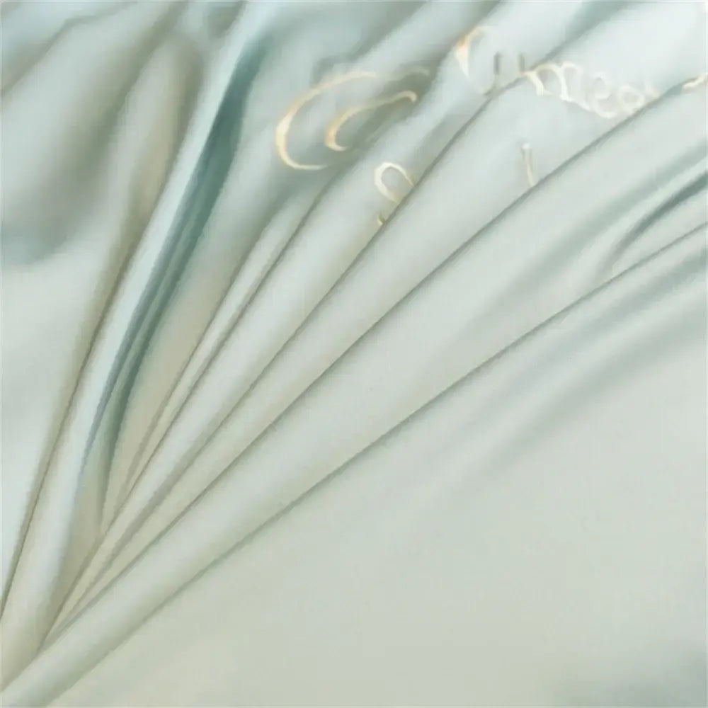 Light blue embroidered egyptian cotton bedding sets featuring soft pale green satin fabric with gold cursive lettering