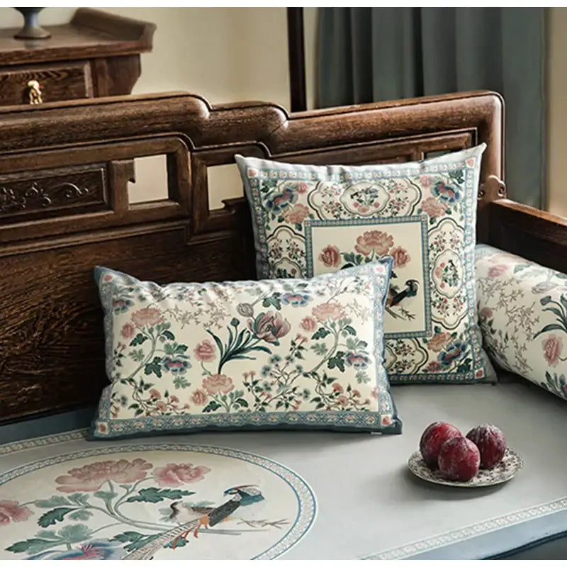 Cream-colored pillow cover with intricate floral and bird motifs in soft pinks and blues for flower fragrance decor