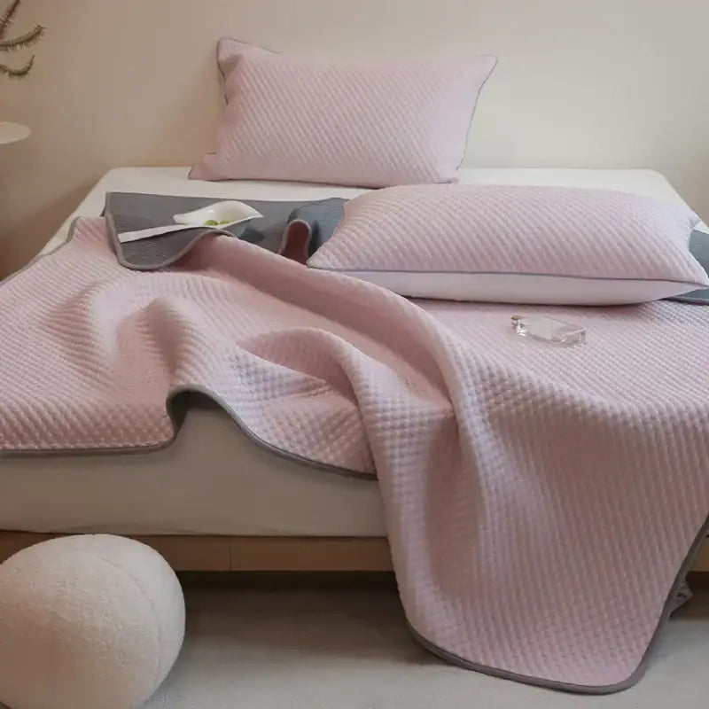 Pink quilted bedspread with a gray border.