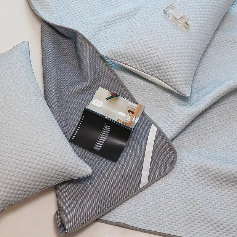 Gray textured decorbites ice bean cooling sleep mat with subtle white stripe from light blue gray bed sheet set