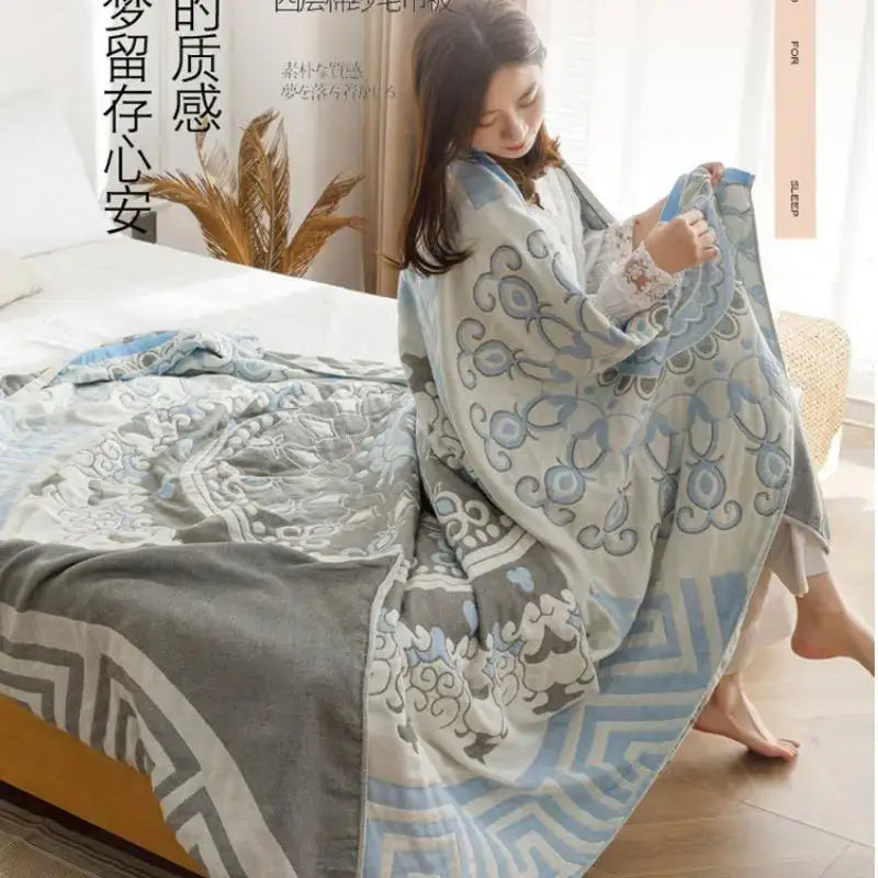 A light blue and gray patterned cotton gauze summer blanket draped over a woman’s shoulders by decorbites cotton gauze