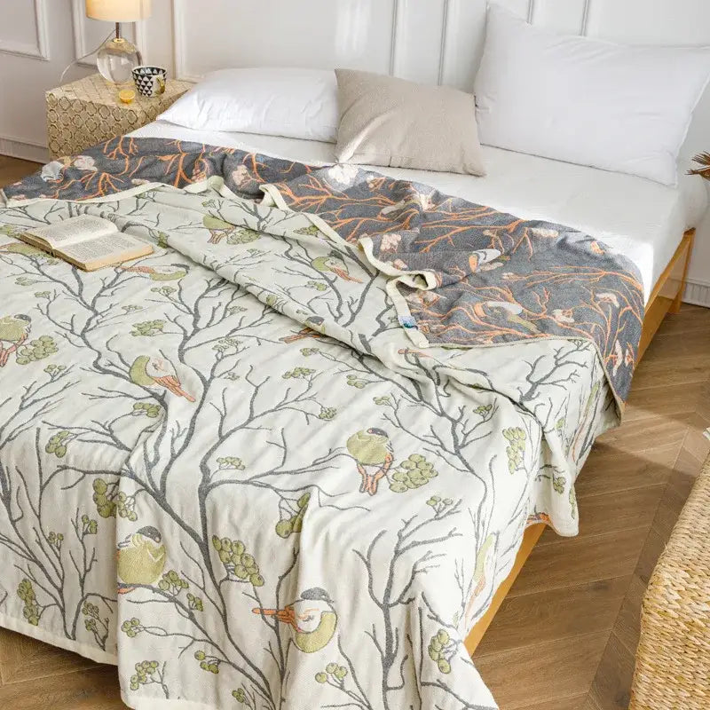A soft cream-colored decorbites cotton gauze summer blanket with green birds and gray branches for bedroom throw