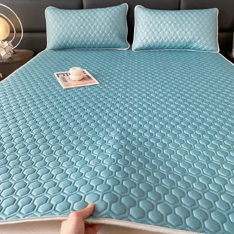 Light blue hexagonal quilted cooling latex filled bed mat with white trim designed for bedroom use