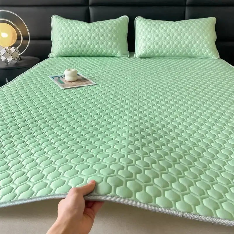 Light green quilted cooling latex filled bed mat with honeycomb texture and gray stitched border for bedroom use