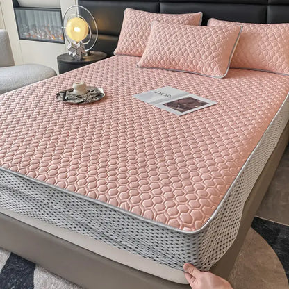 Pink quilted bed mat set with honeycomb texture and gray trim designed as a cooling mattress pad
