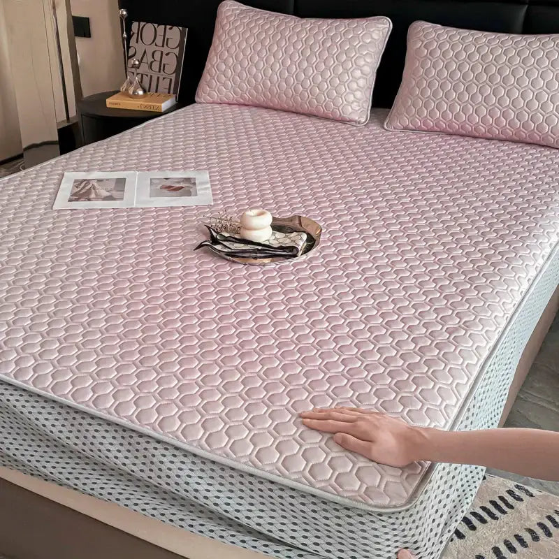 Pink hexagonal quilted mattress pad with light gray border as part of a light blue ice silk cooling bed mat set